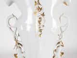 a white vase with a gold decoration on it