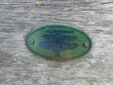 une pancarte en bois sur laquelle est représenté un arbre, posée sur un banc en bois