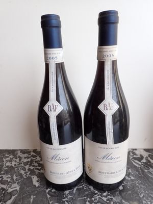 two bottles of wine sitting on a marble table