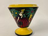 an image of a yellow and black vase with a lady on it