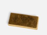a gold bar of soap on a white surface