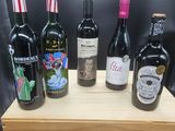 six bouteilles de vin sont alignées sur une caisse en bois