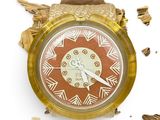 a gold watch with a red face and a brown band