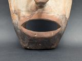 a wooden mask with a hole in the middle of it