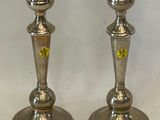 two silver candlesticks sitting on a white table