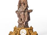 une statue de femme assise au sommet d'une horloge