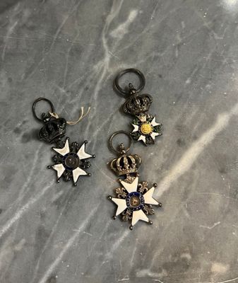 deux paires de boucles d'oreilles en forme d'étoile posées sur une surface en marbre