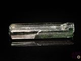 un gros plan d'un cristal vert et blanc sur une surface noire