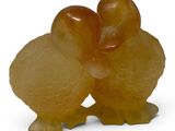 a small figurine of two birds on a white background