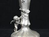 un vase en argent sur lequel est représenté un petit garçon