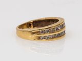 a close up of a gold ring with diamonds on a white surface