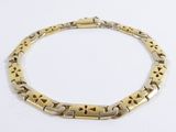 gros plan d'un bracelet en or sur une surface blanche