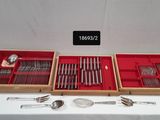 two wooden trays with silverware and spoons on a table