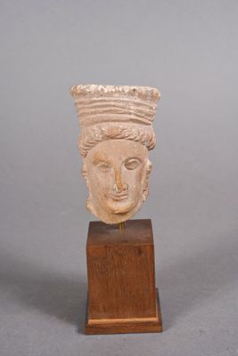 tête sculptée représentant une femme coiffée d'une couronne, posée sur un socle en bois