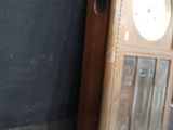 a clock that is sitting on the floor in front of a black wall