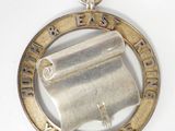 une image représentant une médaille d'argent sur laquelle figure un parchemin