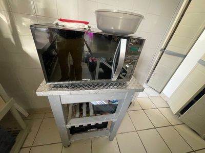 une cuisine équipée d'un micro-ondes et d'un saladier posé sur le plan de travail