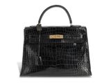 a black crocodile skin handbag on a white background