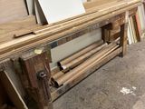 Plusieurs morceaux de bois sont empilés sur un établi dans un atelier