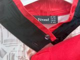 un gros plan d'un t-shirt rouge et noir posé sur un lit