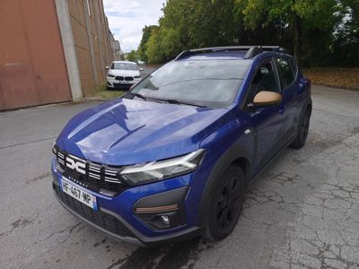 une voiture bleue garée dans un parking à côté d'un bâtiment