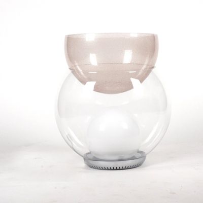 a glass vase that has a ball inside of it