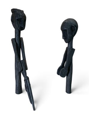 une paire de sculptures noires représentant un homme et une femme tenant des parapluies