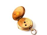 a gold pocket watch with a keychain on a white surface