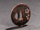 a small round metal object with a design on it