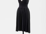 une robe noire posée sur un mannequin, sur fond blanc
