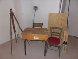a desk with a chair and easel in the corner of a room
