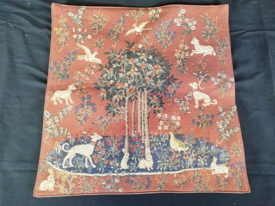 un coussin sur lequel sont représentés un arbre et des animaux
