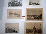 several old black and white pictures of ships on display in a museum