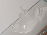 a glass sculpture of a woman sitting on a glass table