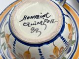 a cup and saucer sitting on a plate with a name written on it