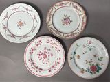 four plates with floral designs are arranged on a gray surface