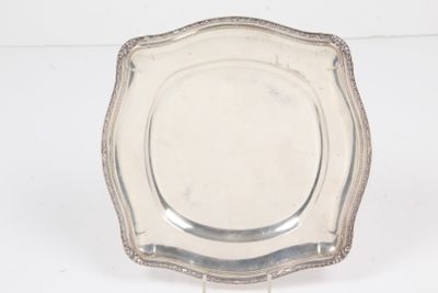 an antique silver plate on a stand on a white background