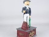 figurine of a man in a top hat with a bag and umbrella