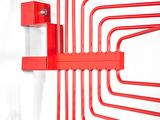 a red metal wall mounted shelf with a bunch of red pipes