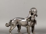 statue en argent représentant un chien portant un chat sur le dos
