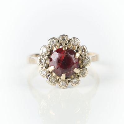 Bague en or gris sertie d'une pierre rouge dans un entourage… - Photo 1