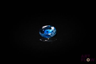 un gros plan d'un saphir bleu sur une surface noire