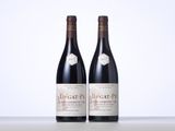 two bottles of red wine sitting next to each other on a table