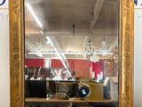 un miroir à cadre doré posé sur une table dans une pièce