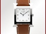 une photo d'une montre carrée blanche avec un bracelet en cuir marron