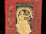 an old red book with gold foil on it sitting on a black surface