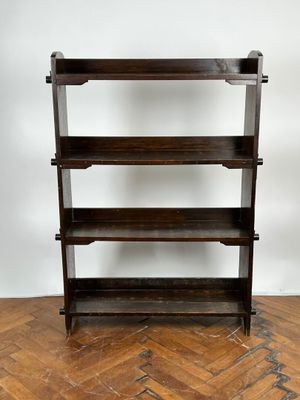 une vieille bibliothèque en bois posée sur un parquet, dans une pièce