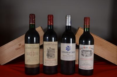 several bottles of wine are lined up on a red cloth