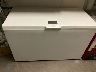 a white chest freezer sitting on the floor in a room