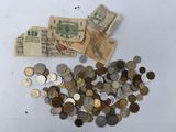 a pile of coins and a bag of money on a table